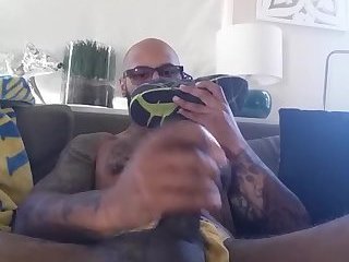 Hot black guy with tatttoos sniffs dirty sneakers while jerking